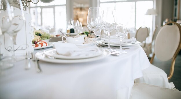 Elegantes weißes Hochzeitstischset mit Tellern, Gabeln und Gläsern