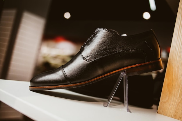 Foto elegantes zapatos de cuero para hombres en el estante de la tienda procesamiento de fotografías antiguas