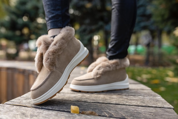 Elegantes zapatos de otoño invierno beige de moda con piel suave y pedrería en el pavimento gris