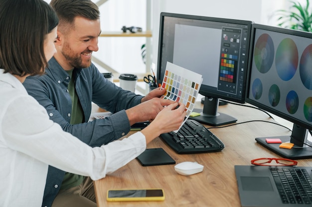 Elegir los colores correctos Dos diseñadores trabajando juntos en la oficina