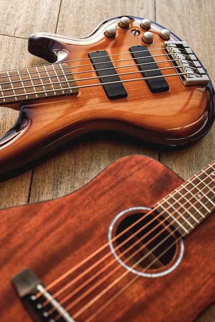 Elegir una guitarra ... Vista superior de dos instrumentos musicales perfectamente pulidos: guitarras acústicas y eléctricas yacen en el suelo de madera de una tienda de música. Instrumentos musicales. Concepto de música. Cuerpo de guitarra