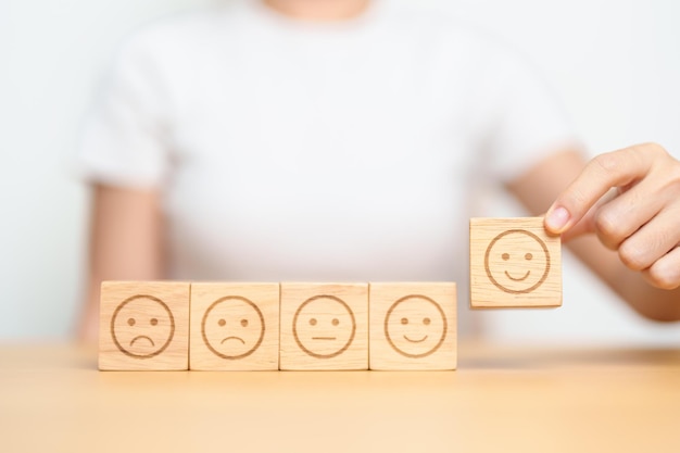 Elegir a mano la cara sonriente del bloque de emociones para la revisión del cliente buena experiencia positiva f