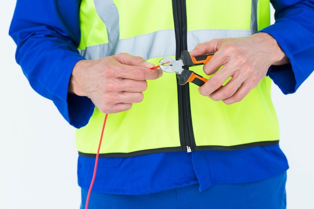 Elektriker, der Draht mit Zangen schneidet