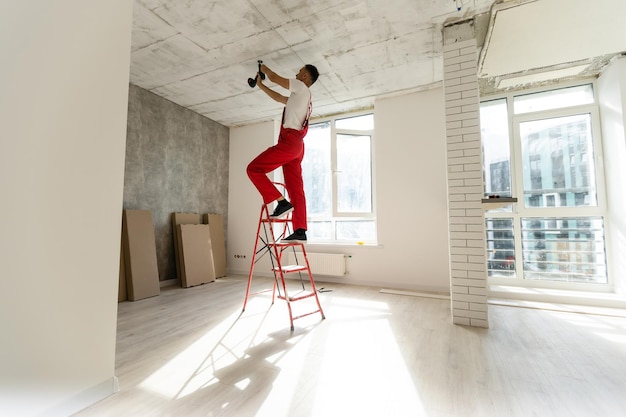 Elektriker, der mit Kabeln in einer neuen Wohnung arbeitet