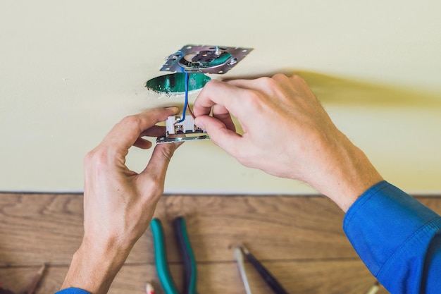 Elektriker, der Steckdose im neuen Haus installiert. Elektriker im Haus