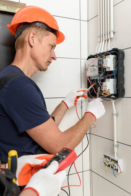 Elektriker prüfen die spannung an den klemmen des stromzählers.