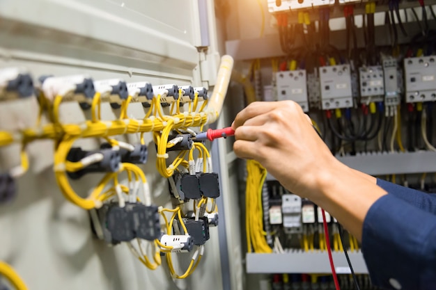 Foto elektrikerhände prüfen aktuelles elektrisches im bedienfeld.