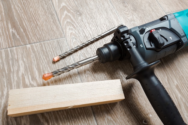 Elektrische Bohrhammer liegt auf einem Holztisch