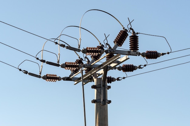 Elektrische Spalte und Drähte der Hochspannung auf Hintergrund des blauen Himmels