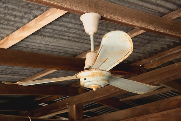 Elektrischer Deckenventilator, alter rostiger Deckenventilator auf rostigem auf Dach im alten Haus