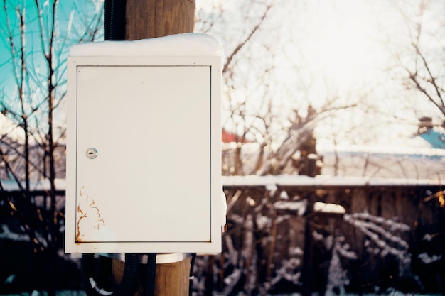 Elektrischer Transformator unter Spannung Wintertag außerhalb der Stadt Sonniger Tag bei kaltem Wetter