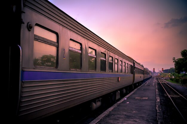 Elektrischer Zug auf Eisenbahn mit Sonnenuntergangdämmerung