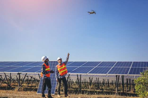 Elektro- und Instrumententechniker fliegen Drohne zu Wartung elektrisches System am Solarpanelfeld