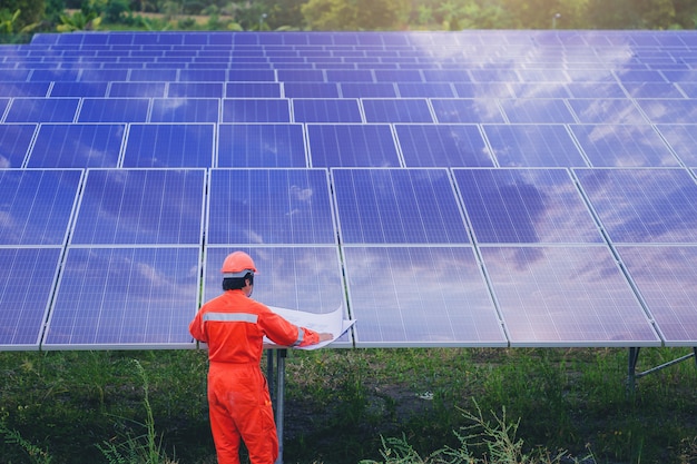 Elektro- und Instrumententechniker verwenden Plan, um elektrisches System am Sonnenkollektorfeld zu planen und zu warten