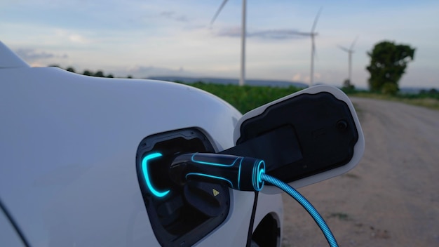 Elektroauto lädt Energie von der Ladestation im Windkraftpark Peruse auf