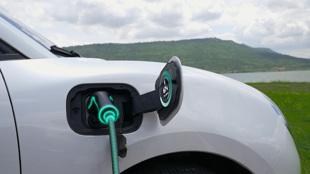 Elektroauto mit Ladestation mit Naturhintergrund angeschlossen