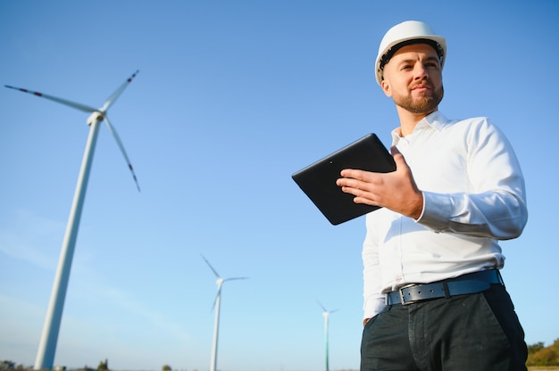 Foto elektroingenieure, die an einer windkraftanlage mit laptop arbeiten