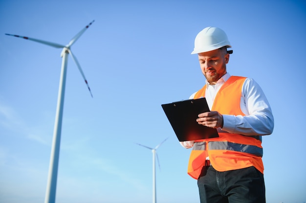 Elektroingenieure, die an einer Windkraftanlage mit Laptop arbeiten