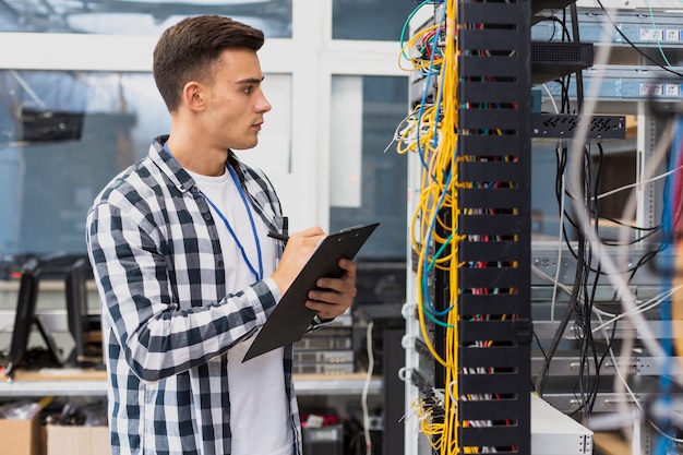 Foto elektrotechniker, der auf netzschalter schaut