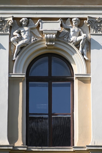 Foto elemente der klassischen architektur mit zwei skulpturen von engeln über dem fenster