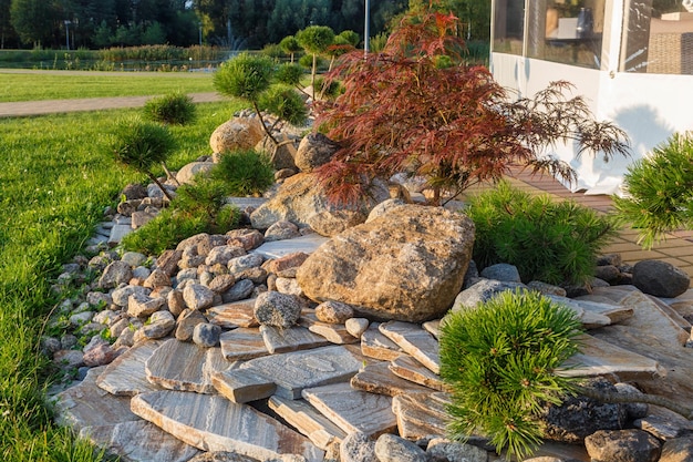 Elemente der modernen Landschaftsgestaltung in der Nähe von Restaurants. Druskininkai. Litauen. Zierstein, Koniferen.