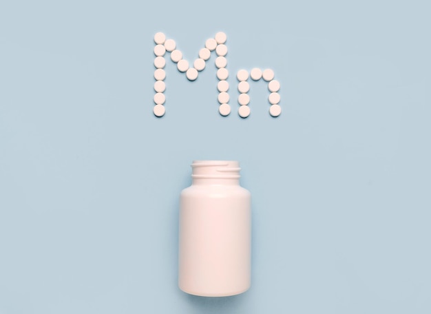 Elemento químico Manganês Mn ícone de comprimidos e frasco de drogas em fundo azul Colltction de vitaminas e minerais