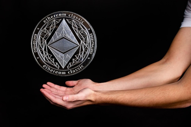 Los elementos de la criptomoneda clásica ethereum caen en la mano. Fondo negro