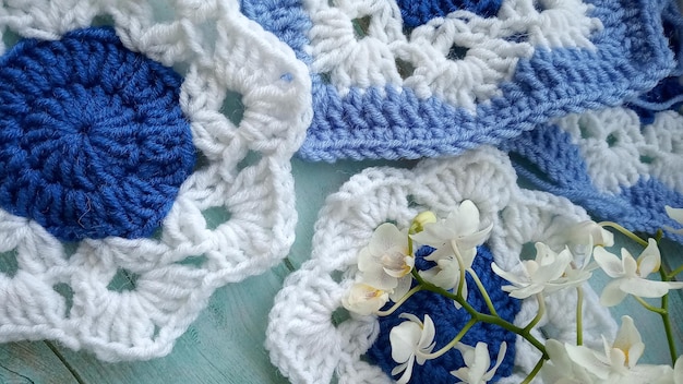 Elementos de crochet azul-branco e textura de orquídea Crochet lugar para uma inscrição adaptada para móvel