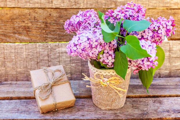 Elementos de decoración floral pequeña caja de regalo con regalos envueltos en papel marrón artesanal con ramo de flores ...