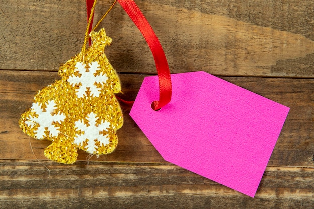 Elementos decorativos de natal ao lado do cartão com fita vermelha e espaço para escrever