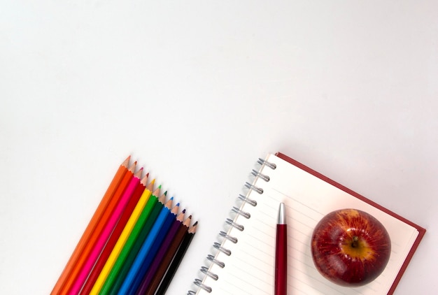 Elementos educativos creativos en fondo blanco utilizados en el concepto de Regreso a la escuela Vista superior de lápices multicolores y material de estudio para niños que aprenden diseño de carteles