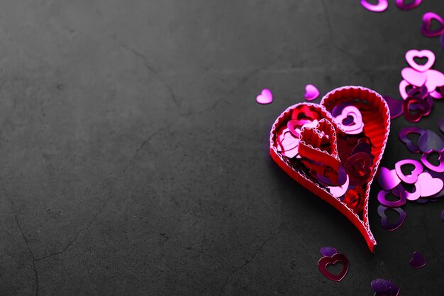 Elementos de papel en forma de corazón sobre fondo de piedra oscura. Concepto de amor y día de San Valentín. Diseño de tarjeta de felicitación de cumpleaños.