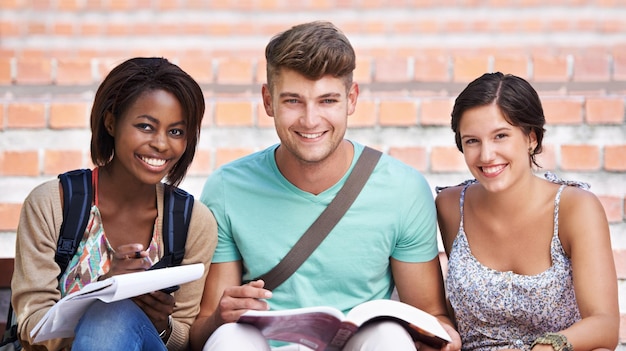 Foto eles adoram estudar retrato de três estudantes sorridentes nos degraus do campus universitário