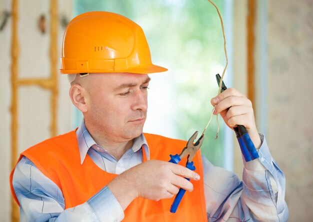 Eletricista consertando a fiação do teto da casa