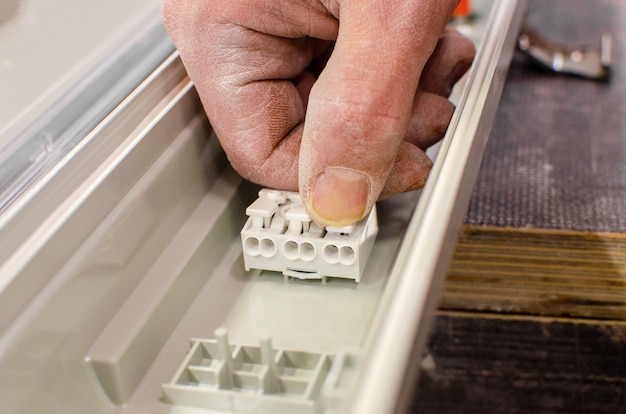 Eletricista instala lâmpadas fluorescentes no teto. conceito de reparo e manutenção. conectando conectores elétricos.