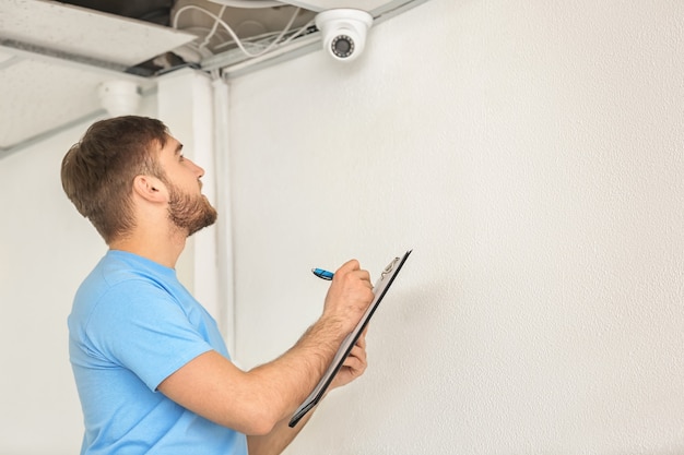 Eletricista instalando câmera de segurança dentro de casa