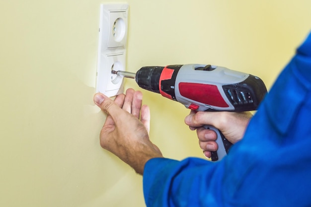 Eletricista instalando soquete na casa nova. Eletricista em casa