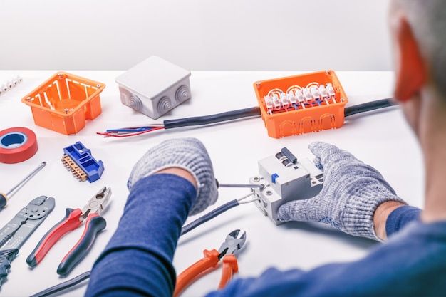 Eletricista que trabalha no painel elétrico. Serviço de equipamentos elétricos.