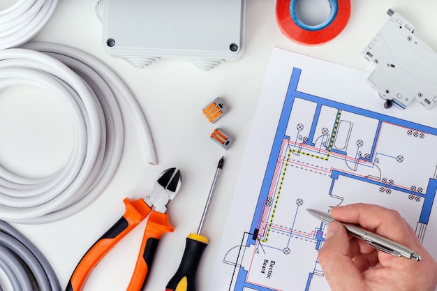 Eletricista que verifica os planos elétricos. reparação do conceito de equipamentos elétricos.