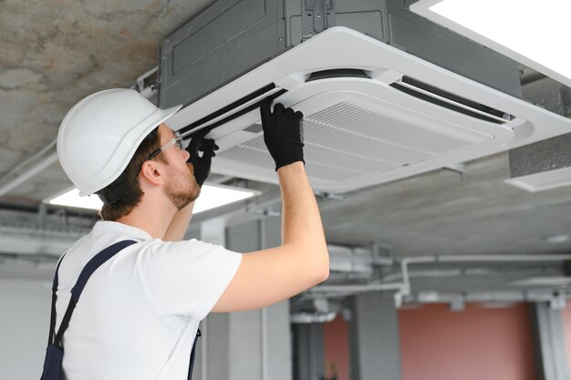 Eletricista reparando ar condicionado em ambientes fechados