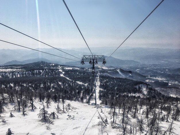 Foto elevación de esquí sobre tierra cubierta de nieve contra el cielo