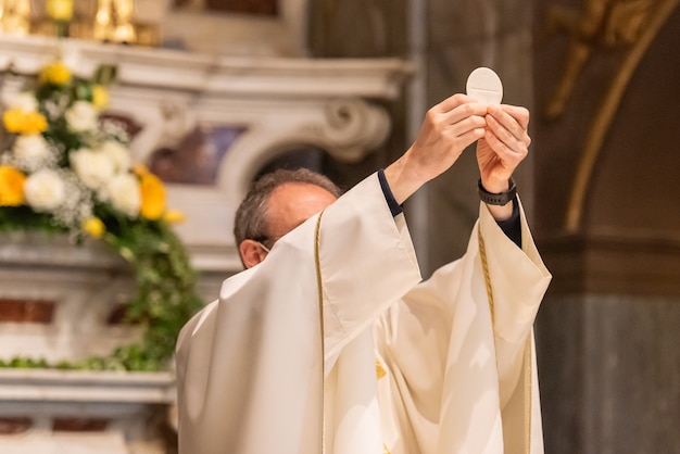 Foto la elevación del pan sacramental durante la liturgia católica