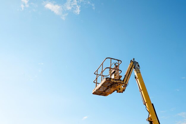 Elevador de brazo telescópico se elevó sobre fondo de cielo azul entregado al sitio de contracción listo para ser utilizado