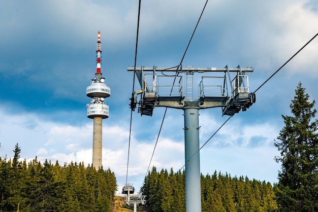 Elevador com cabo passa entre a floresta de abetos no pico contra o pano de fundo das cadeias montanhosas das Montanhas Rhodope