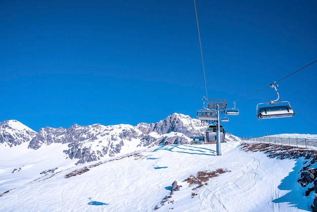 Elevador de esqui na bela montanha de neve contra o céu azul