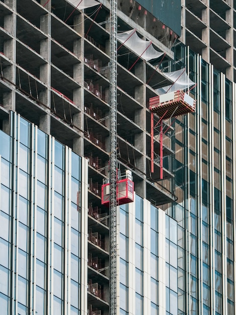 Elevadores elevam para os canteiros de obras de um arranha-céu em construção