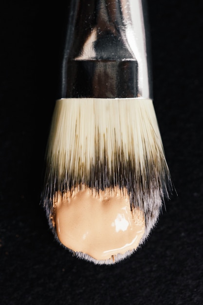 Elfenbein-Hautfundament auf einem Make-up Pinsel