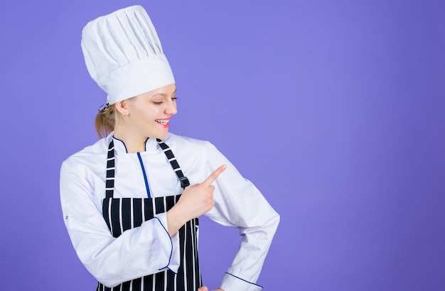 Elija elementos del menú a la carta Bonita cocinera señalando con el dedo y ofreciendo el menú Publicidad para el menú de su restaurante Espacio de copia de la lista del menú