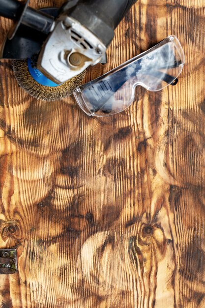 Eliminación de pintura de una tabla de madera con herramientas y gafas.