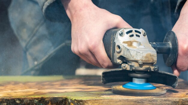 Eliminación de pintura de una tabla de madera con herramientas.